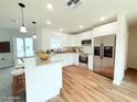 Modern white kitchen with stainless steel appliances and a breakfast bar overlooks the living area at 222 Carpenters Way # 71, Lakeland, FL 33805