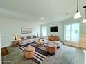 Bright living room is furnished with modern furniture, a TV, and a stylish rug at 222 Carpenters Way # 71, Lakeland, FL 33805