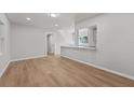Open living room with hardwood floors, light gray walls, and view to an adjacent room with bar counter at 2800 E Anderson St, Orlando, FL 32803