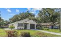 Exterior view of a one story home featuring dark trim, an attached garage, and a landscaped yard at 9413 5Th Ave, Orlando, FL 32824