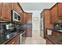 Modern kitchen featuring granite countertops, stainless steel appliances, and dark wood cabinets at 4221 Meadowbend Ct, Lakeland, FL 33811