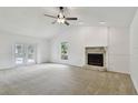 Bright living room boasts a stone fireplace, neutral carpet, and double glass doors at 4221 Meadowbend Ct, Lakeland, FL 33811