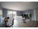 Staged living room with tile floors, a dining table, and a sliding glass door at 1920 E Edgewood Dr # E1, Lakeland, FL 33803
