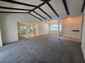 Open-concept living area featuring neutral paint, beams and seamless flow into the kitchen at 454 San Jose Dr, Winter Haven, FL 33884