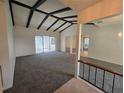 Spacious living room with a vaulted ceiling and dark wood beams, leading to an outdoor area at 454 San Jose Dr, Winter Haven, FL 33884