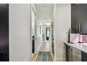 Hallway with white walls and hardwood floors leads to a black door at 12684 Willstatter Ave, Orlando, FL 32827