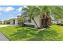Corner view of the house exterior featuring neatly trimmed hedges and a palm tree at 3582 Milano Ave, Lakeland, FL 33803