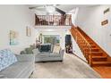 Bright living room featuring wood staircase, cozy seating, and a view to a loft area at 940 Fenton Ln # 7, Lakeland, FL 33809