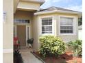 Inviting front entrance with decorative plants, a chair, and updated windows at 7055 Heatherbrook Dr, Lakeland, FL 33809