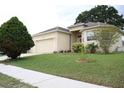 Single-Gathering home exterior with lush green lawn, mature trees, and side-entry three-car garage at 7055 Heatherbrook Dr, Lakeland, FL 33809