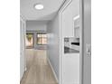Hallway with wood flooring and access to a well-lit kitchen area at 4160 Player Cir # 109, Orlando, FL 32808