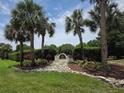 Community entrance showcasing landscaping with a decorative stone border and mature palm trees at 4471 Marsh Harbor Dr, Tavares, FL 32778