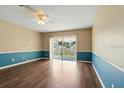 Bright living room features hardwood floors, sliding glass doors to the patio, and a ceiling fan at 6125 Morningdale Ave, Lakeland, FL 33813