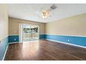 Spacious living room with hardwood floors, sliding glass doors to the patio, and a ceiling fan at 6125 Morningdale Ave, Lakeland, FL 33813
