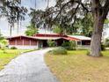 Charming home exterior featuring a long driveway, mature trees, and well-kept landscaping at 2292 Se 170Th Avenue Rd, Silver Springs, FL 34488