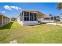 Exterior of home featuring a screened porch and covered parking, complemented by lush lawn at 97 Parson Dr, Winter Haven, FL 33884