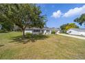 Well-maintained single-story home with lush green lawn, mature shade tree and long driveway at 8225 Sw 108Th Street Rd, Ocala, FL 34481