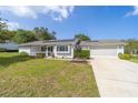 Attractive one-story home featuring a well-kept lawn, solar panels, and two-car garage at 8225 Sw 108Th Street Rd, Ocala, FL 34481