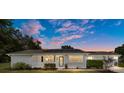 Inviting single-story home with solar panels, front porch, and professionally landscaped yard at twilight at 8225 Sw 108Th Street Rd, Ocala, FL 34481