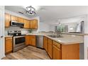 Functional kitchen featuring stainless steel appliances, wood cabinets, and wood-look flooring at 9700 Sw 196 Circle, Dunnellon, FL 34432