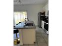 Bright kitchen with stainless steel appliances, a granite countertop island, and neutral-toned tile flooring at 15094 Sw 43Rd Avenue Rd, Ocala, FL 34473