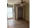 Bright bedroom featuring wood-look floors, a ceiling fan, and a closet at 2123 Woodburn S Loop, Lakeland, FL 33813