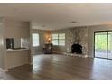 Inviting living room with a stone fireplace, wood-look floors, and lots of natural light at 2123 Woodburn S Loop, Lakeland, FL 33813