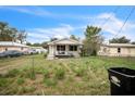 Simple home with a chain link fence and grassy front yard under a sunny sky at 303 Clayton Rd, Auburndale, FL 33823