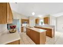 Bright kitchen with a large island, white countertops, oak cabinetry, and stainless steel appliances at 3826 Sleepy Hill Oaks Loop, Lakeland, FL 33810