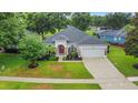 Inviting single-story home with lush landscaping and a two car garage at 3897 Beacon Ridge Way, Clermont, FL 34711