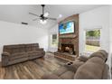 Cozy living room with brick fireplace, vaulted ceiling, and wood-look floors at 722 Swaying Palm Dr, Apopka, FL 32712