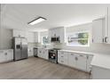 Bright kitchen featuring white cabinets, stainless steel appliances, modern lighting, and a large window at 837 E Edgewood Dr, Lakeland, FL 33803
