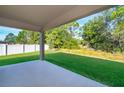 Covered patio overlooking a spacious backyard with a privacy fence and lush green grass at 27 Perch Dr, Kissimmee, FL 34759