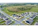 Aerial view of a residential neighborhood featuring modern homes, well-maintained lawns, and a surrounding green landscape at 271 Inman Blvd, Winter Haven, FL 33881