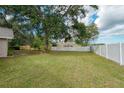 Large, fenced backyard with mature trees, offering privacy and ample space at 4462 Iris S St, Lakeland, FL 33813