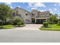 Elegant two-story home showcasing lush landscaping, a balcony, and a circular driveway for a grand entrance at 9080 Morgana Ct, Winter Garden, FL 34787