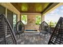 Covered patio with stone accents, featuring a water feature and stylish egg chairs for outdoor relaxation at 9080 Morgana Ct, Winter Garden, FL 34787