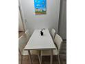 Bright dining area features a modern white table and chairs set, complemented by playful wall art at 7601 Canada Ave # 220, Orlando, FL 32819