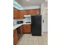This kitchen features wooden cabinets, white counters, and black appliances at 7601 Canada Ave # 220, Orlando, FL 32819