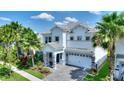 Stunning two-story home showcasing lush landscaping, a paved driveway, and a two-car garage at 1423 Bunker Dr, Davenport, FL 33896