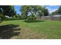 Large backyard featuring mature trees, lush lawn, and a tall wooden fence at 3115 Lake Arnold Pl, Orlando, FL 32806