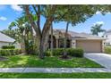 Well-maintained home featuring a manicured front yard, mature trees, and a welcoming facade at 433 Woodcrest St, Winter Springs, FL 32708