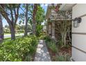 Beautifully landscaped walkway leads to the front entrance of this charming home with mature trees and flowering shrubs at 433 Woodcrest St, Winter Springs, FL 32708