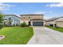 Inviting two-story home featuring manicured lawn, tidy landscaping, and a two-car garage at 5660 Keaton Springs Dr, Lakeland, FL 33811