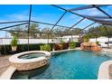 Sparkling pool and spa are enclosed, with mature landscaping and a waterfall feature at 6143 Black Walnut Dr, Bartow, FL 33830