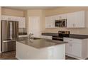 Modern kitchen featuring white cabinets, stainless steel appliances, and an island with a gray countertop at 770 Ambleside Dr, Haines City, FL 33844