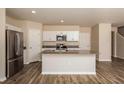 Well-lit kitchen with a center island, stainless steel appliances, and wood flooring throughout at 770 Ambleside Dr, Haines City, FL 33844