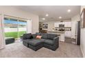 Open-concept living room featuring a gray sofa and a view of the adjacent kitchen at 1368 Axel Cir, Winter Haven, FL 33880