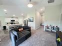 Open-concept living area with a cozy couch, modern kitchen with stainless steel appliances, and a view of the hallway at 1368 Axel Cir, Winter Haven, FL 33880