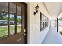 Inviting front entryway with a decorative glass door and a sleek, covered walkway with a view of the landscaped yard at 229 Temple Ave, Fern Park, FL 32730